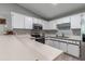 Well-lit kitchen boasts ample countertop space, white cabinetry, and modern stainless steel appliances at 201 W Mirror Lake Dr, Fruitland Park, FL 34731