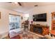 Cozy living room with a fireplace, sliding glass doors to the patio, and a ceiling fan at 201 W Mirror Lake Dr, Fruitland Park, FL 34731