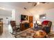 Bright and airy living room showcasing comfortable seating, decorative rug, fireplace and vaulted ceiling at 201 W Mirror Lake Dr, Fruitland Park, FL 34731