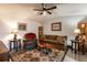 Comfortable living room featuring a sofa, arm chair, decorative rug, and a ceiling fan at 201 W Mirror Lake Dr, Fruitland Park, FL 34731