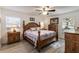 Comfortable main bedroom features a wooden bed frame, ceiling fan, and two windows for ample light at 201 W Mirror Lake Dr, Fruitland Park, FL 34731