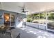 Covered and screened lanai with tile floor, ceiling fan, and view to outdoor foliage at 201 W Mirror Lake Dr, Fruitland Park, FL 34731