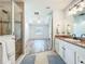 Open bathroom with a glass shower, wood-look floors in the bedroom, and a granite countertop at 203 Se 30Th Ave, Ocala, FL 34471