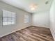 Bedroom featuring wood-look floors, light gray walls, and two windows at 203 Se 30Th Ave, Ocala, FL 34471