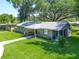 Inviting exterior of a charming home featuring a circular driveway, lush lawn, and comfortable porch area at 203 Se 30Th Ave, Ocala, FL 34471