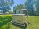 Backyard generator in a grassy yard with trees and the shed at 203 Se 30Th Ave, Ocala, FL 34471