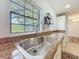 Kitchen view featuring stainless steel sink and faucet beneath window, paired with stylish countertops and white cabinetry at 203 Se 30Th Ave, Ocala, FL 34471