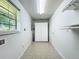Bright laundry room with a window, tile floor, storage cabinet and a door to another room at 203 Se 30Th Ave, Ocala, FL 34471