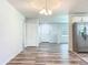 Open-concept living space with wood-look floors, an elegant chandelier, and a stainless steel refrigerator at 203 Se 30Th Ave, Ocala, FL 34471