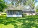 A screened porch offers an outdoor living space for relaxation with views of the landscaped backyard at 203 Se 30Th Ave, Ocala, FL 34471
