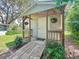 Backyard shed with a covered porch and hanging plants at 203 Se 30Th Ave, Ocala, FL 34471