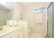Bright bathroom with glass block window and framed mirror above the vanity at 20631 Prince Ranier Pl, Leesburg, FL 34748