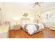 Bright bedroom with hardwood floors, ceiling fan, and large window at 20631 Prince Ranier Pl, Leesburg, FL 34748