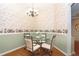 Cozy breakfast nook with glass-top table, chandelier, and vintage-themed wallpaper at 20631 Prince Ranier Pl, Leesburg, FL 34748