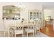 Elegant dining area with chandelier, wood floors, and views to the kitchen and sitting area at 20631 Prince Ranier Pl, Leesburg, FL 34748