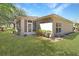 Home exterior with well-manicured lawn, lush landscaping, and a screened patio at 20631 Prince Ranier Pl, Leesburg, FL 34748