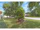 Well-kept front yard featuring lush landscaping, mature trees, and a charming curb appeal at 20631 Prince Ranier Pl, Leesburg, FL 34748