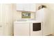 Well-equipped laundry room with washer, dryer, and additional storage at 20631 Prince Ranier Pl, Leesburg, FL 34748
