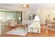 Bright and airy living room with hardwood floors and large windows, adjacent to dining area at 20631 Prince Ranier Pl, Leesburg, FL 34748