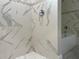 Elegant walk-in shower featuring marble-look tile and stylish fixtures, adjacent to a soaking tub at 217 S East St, Leesburg, FL 34748