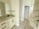 Bright bathroom featuring a granite vanity, white cabinets, a mirror, and a shower with marble-look tile at 217 S East St, Leesburg, FL 34748
