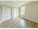 Bedroom featuring a closet, a window, and wood look flooring at 217 S East St, Leesburg, FL 34748