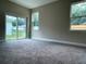 Cozy bedroom featuring plush carpet, natural light, and a sliding glass door to the outside at 217 S East St, Leesburg, FL 34748