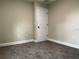 Empty bedroom with neutral walls, carpet, and a door at 217 S East St, Leesburg, FL 34748