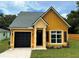 Charming one-story home showcasing yellow siding, a black garage door, and a well-maintained lawn at 217 S East St, Leesburg, FL 34748