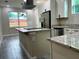 Modern kitchen boasting a granite island, stainless steel appliances, and white cabinets at 217 S East St, Leesburg, FL 34748