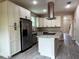 Bright kitchen featuring white cabinetry, stainless steel appliances, and a granite island at 217 S East St, Leesburg, FL 34748