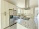 A modern kitchen featuring granite countertops, stainless steel appliances, ample cabinet space, and sleek vent hood at 217 S East St, Leesburg, FL 34748