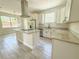A modern kitchen equipped with white cabinets, granite countertops, stainless steel appliances, and an island cooktop at 217 S East St, Leesburg, FL 34748