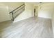 Open living room with staircase, light wood-look tile flooring, and abundant natural light at 217 S East St, Leesburg, FL 34748