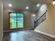 Open living room featuring vaulted ceilings, wood-look tile flooring, and a staircase at 217 S East St, Leesburg, FL 34748