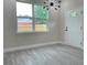 Bright living room featuring wood-look flooring, a modern light fixture, and a large window at 217 S East St, Leesburg, FL 34748