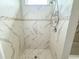 Modern shower with marble-look tiles, decorative accents, and a recessed showerhead, offering a luxurious experience at 217 S East St, Leesburg, FL 34748