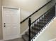 Carpeted staircase features a sleek black handrail and leads to the upper level of the home at 217 S East St, Leesburg, FL 34748