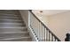 Modern staircase with wood-look steps, black metal railing, and stylish pendant lighting overhead at 217 S East St, Leesburg, FL 34748