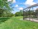 Expansive backyard features lush green lawn and screened-in lanai for outdoor enjoyment at 2259 Lockwood Loop, The Villages, FL 32162