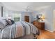 Bedroom with wood floors, a window, dresser, and a ceiling fan at 2259 Lockwood Loop, The Villages, FL 32162