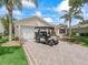 Charming home with golf cart parked in driveway lined with manicured landscaping at 2259 Lockwood Loop, The Villages, FL 32162