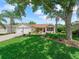Inviting single-story home with a spacious lawn, mature trees, and a two-car garage at 2259 Lockwood Loop, The Villages, FL 32162
