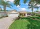 Charming single-story home with a well-manicured lawn, mature trees, and a two-car garage at 2259 Lockwood Loop, The Villages, FL 32162