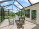 Enclosed lanai featuring outdoor dining set with view to backyard at 2259 Lockwood Loop, The Villages, FL 32162