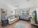 Cozy living room with ample seating, hardwood floors, and natural light from a large window at 2259 Lockwood Loop, The Villages, FL 32162