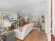 Open-concept living space with hardwood floors, comfortable seating, and a view into the kitchen and dining area at 2259 Lockwood Loop, The Villages, FL 32162