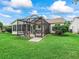Charming screened-in patio with outdoor seating overlooking a lush green backyard at 2259 Lockwood Loop, The Villages, FL 32162