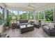 Bright sunroom with large windows, comfortable seating, and views of the lush green landscape at 2259 Lockwood Loop, The Villages, FL 32162