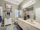 Bathroom featuring double sinks, marble countertops, decorative fixtures, and neutral paint at 24436 Madewood Ave, Leesburg, FL 34748